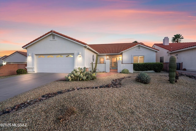 mediterranean / spanish home featuring a gate, fence, driveway, and an attached garage