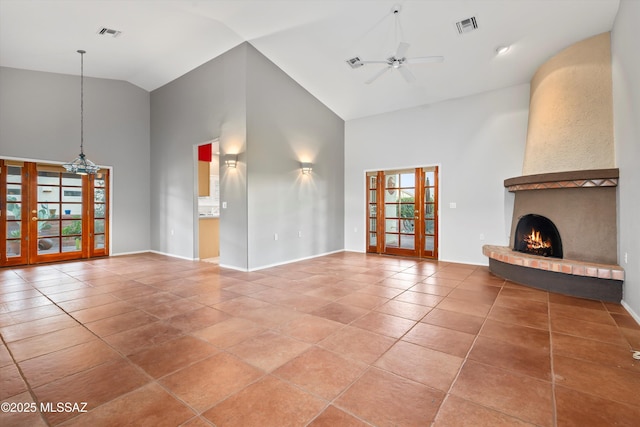 unfurnished living room with high vaulted ceiling, a large fireplace, visible vents, and a ceiling fan