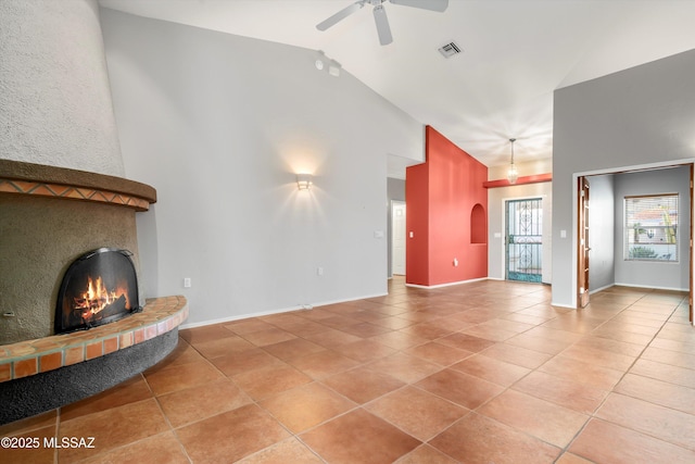 unfurnished living room with a glass covered fireplace, visible vents, baseboards, and light tile patterned flooring