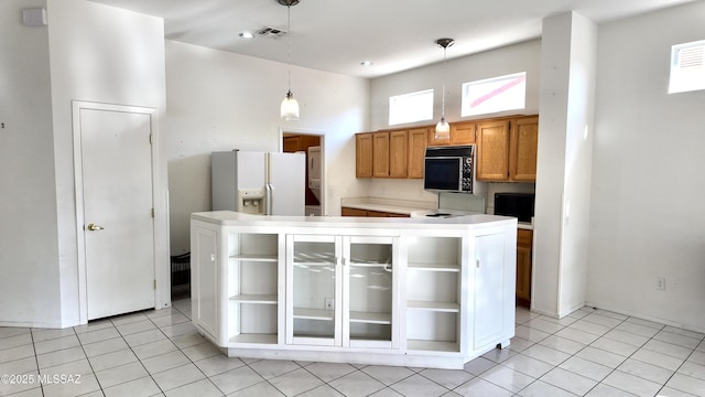 kitchen featuring black microwave, a high ceiling, white fridge with ice dispenser, open shelves, and brown cabinetry