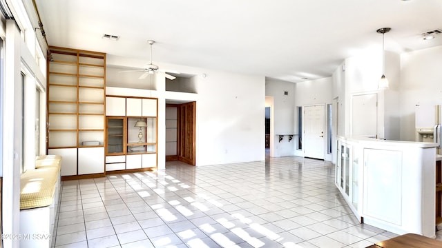 kitchen with light tile patterned floors, ceiling fan, visible vents, white cabinets, and open floor plan