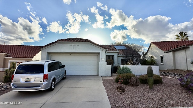 view of front of property featuring a garage, fence, driveway, a tiled roof, and stucco siding