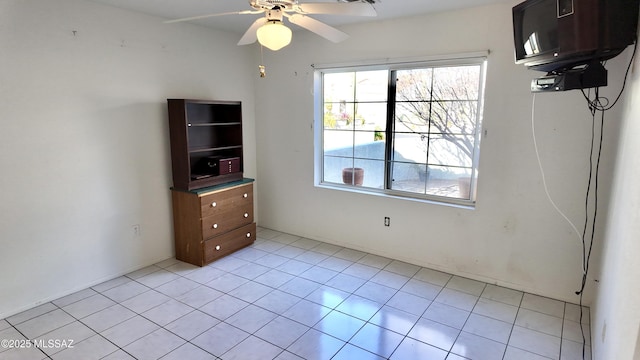 spare room with light tile patterned floors and a ceiling fan