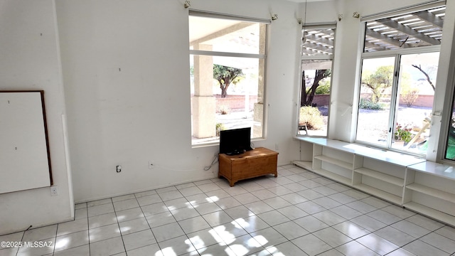 interior space with light tile patterned floors and a healthy amount of sunlight