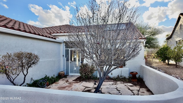 view of front facade featuring a tile roof and stucco siding