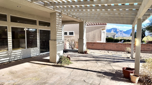 view of patio featuring fence, a mountain view, and a pergola