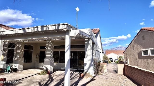 back of property with stucco siding, a patio, and a pergola