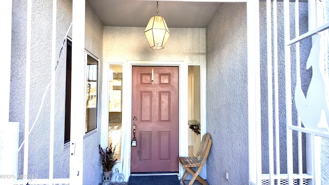 doorway to property featuring stucco siding