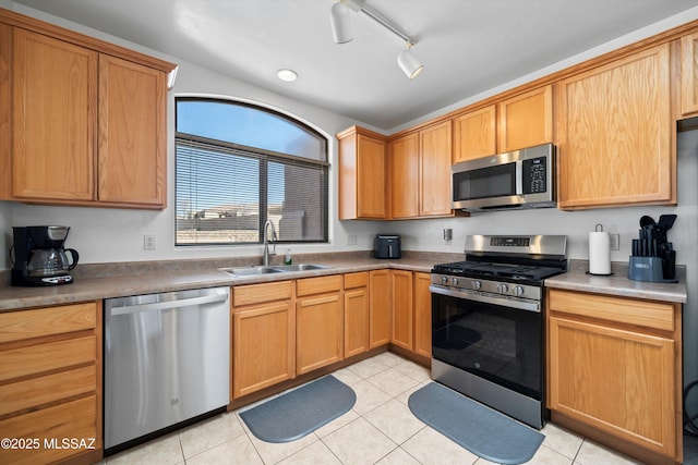 kitchen featuring a sink, stainless steel appliances, and light tile patterned floors