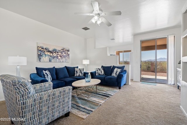 living room featuring visible vents, carpet floors, and ceiling fan