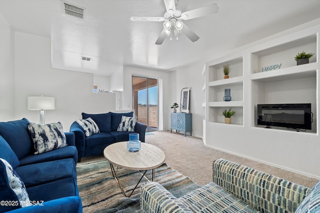 carpeted living room featuring visible vents, baseboards, a ceiling fan, and built in features