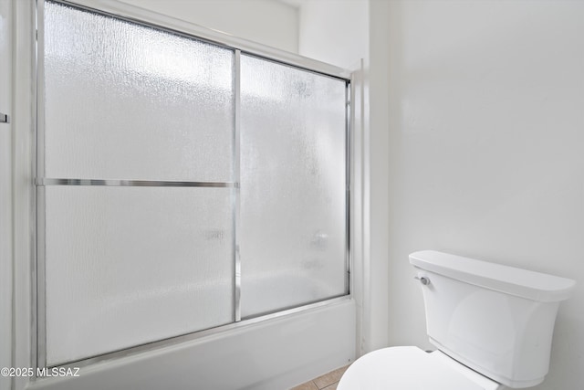 full bathroom with toilet and bath / shower combo with glass door