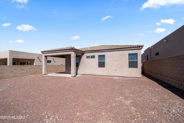 back of property with stucco siding, a patio, a fenced backyard, and a tiled roof