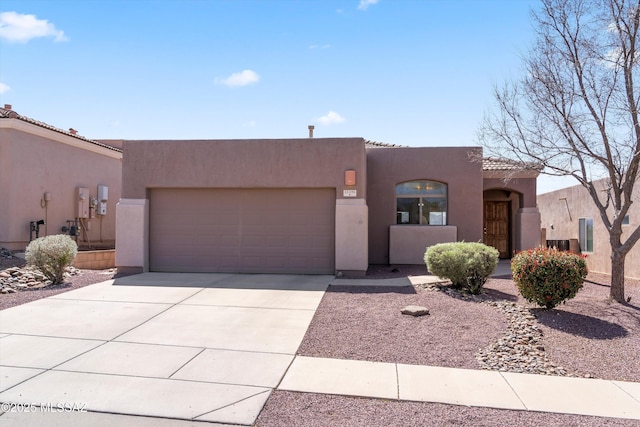 adobe home featuring a tiled roof, concrete driveway, central AC unit, stucco siding, and a garage