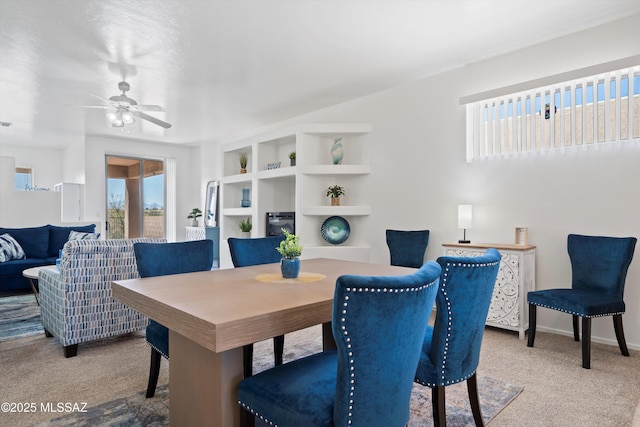 carpeted dining area featuring baseboards and a ceiling fan