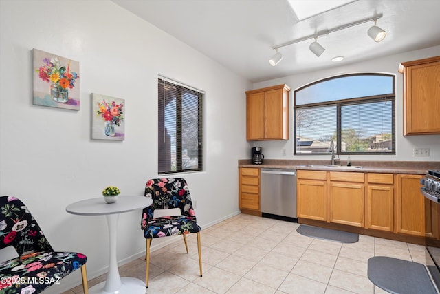 kitchen with dishwasher, light tile patterned flooring, baseboards, and a sink