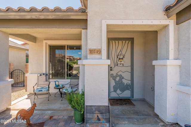 view of exterior entry featuring a tiled roof and stucco siding