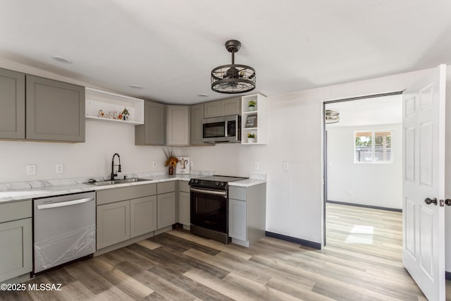 kitchen with gray cabinets, appliances with stainless steel finishes, open shelves, and a sink