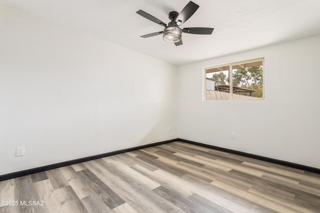 empty room with a ceiling fan, baseboards, and wood finished floors