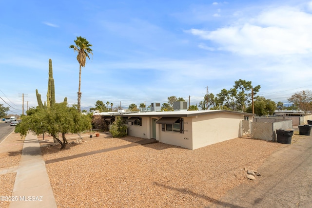 view of front of property featuring fence and stucco siding