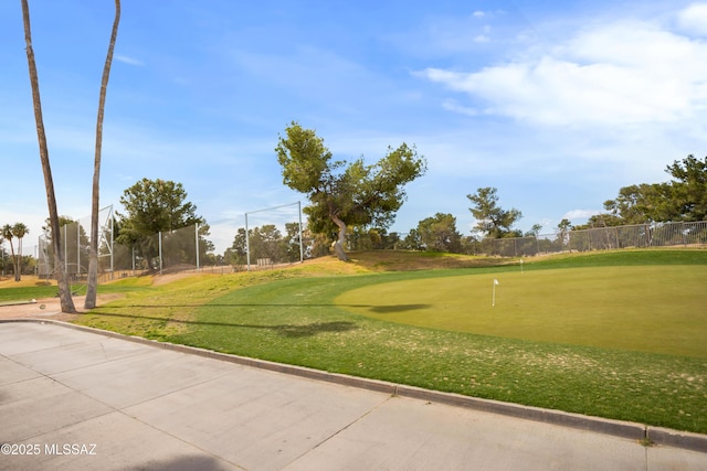 view of property's community with view of golf course and fence