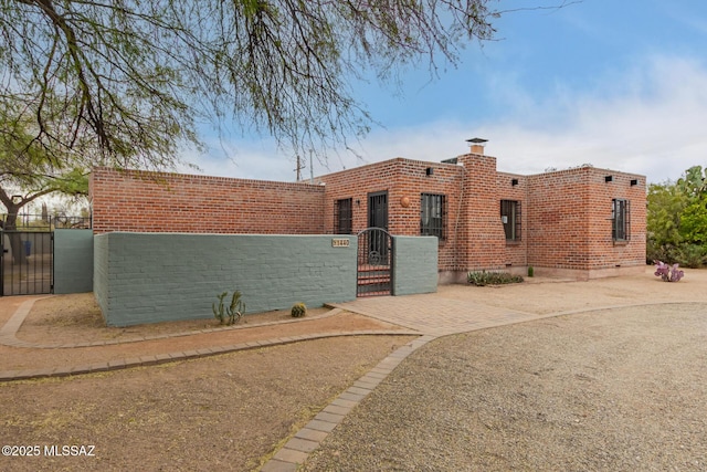 view of front of property with a fenced front yard and a gate