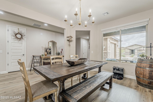 dining room featuring light wood-style flooring, visible vents, and baseboards