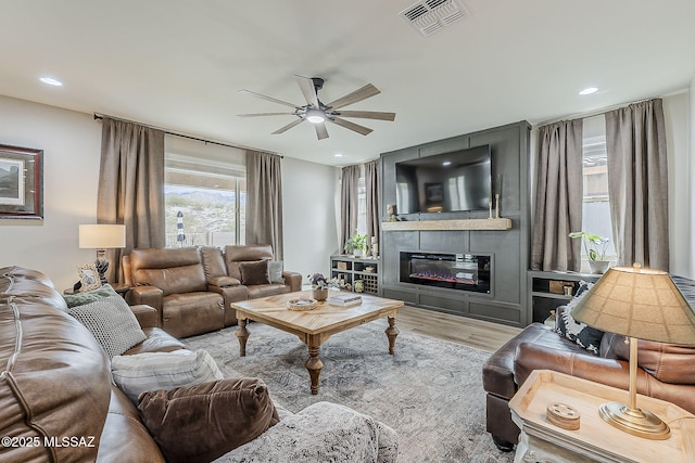 living area featuring visible vents, ceiling fan, wood finished floors, a fireplace, and recessed lighting