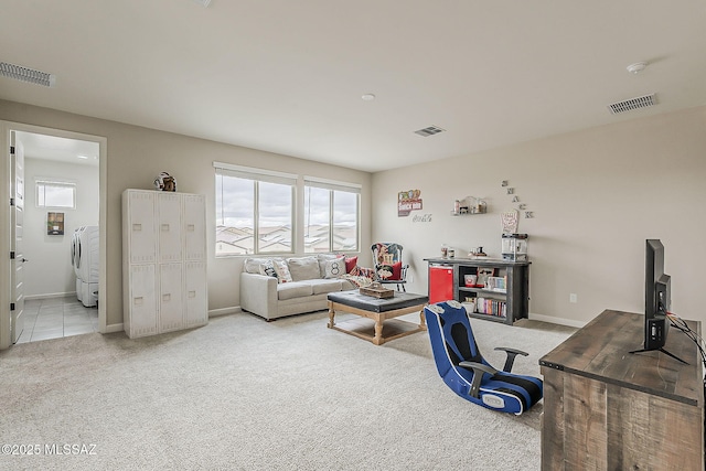 office space featuring visible vents, washer / dryer, and light colored carpet