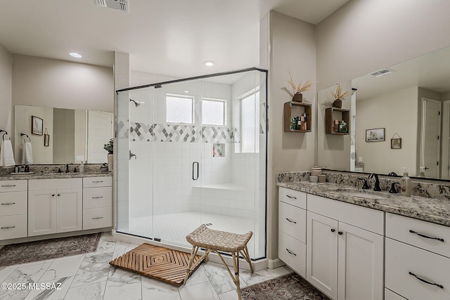 full bath featuring marble finish floor, a sink, visible vents, and a shower stall