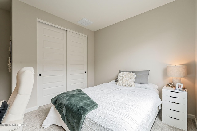 carpeted bedroom with a closet and visible vents