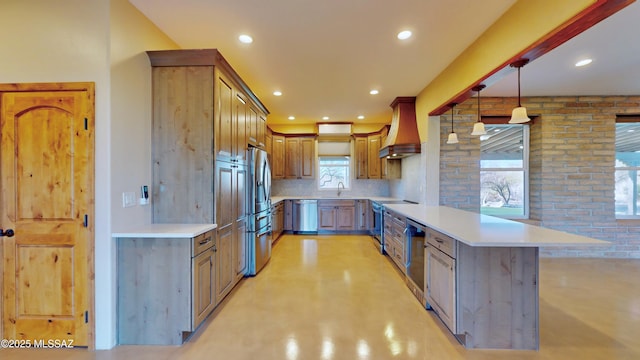 kitchen featuring decorative backsplash, appliances with stainless steel finishes, a peninsula, light countertops, and premium range hood