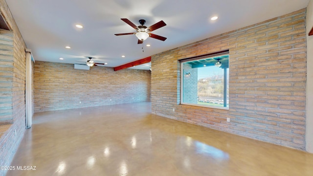 empty room with recessed lighting, concrete floors, and brick wall