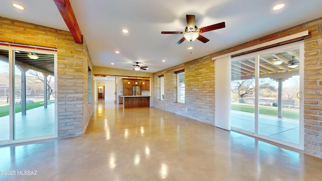 unfurnished living room featuring a ceiling fan, brick wall, beamed ceiling, concrete floors, and recessed lighting