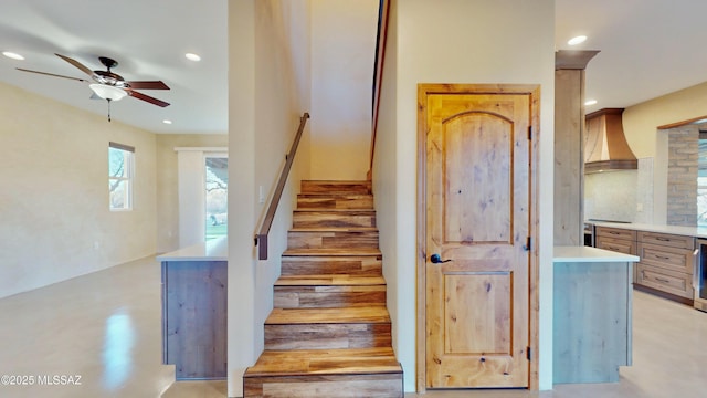 stairs featuring a ceiling fan, recessed lighting, and finished concrete flooring