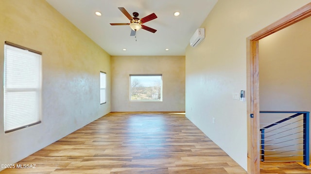 unfurnished room with recessed lighting, a wall mounted air conditioner, ceiling fan, and wood finished floors