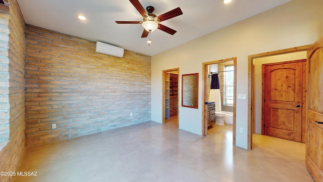 unfurnished room with ceiling fan, recessed lighting, brick wall, an AC wall unit, and finished concrete floors