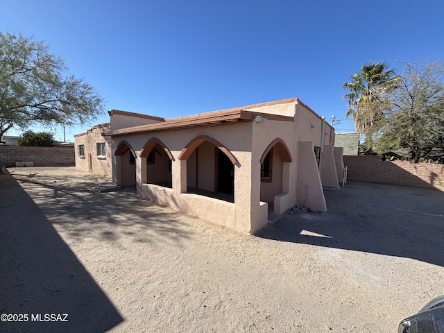 view of front of house featuring fence and stucco siding