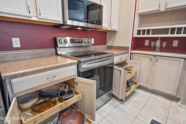 kitchen with appliances with stainless steel finishes, light countertops, light tile patterned flooring, and open shelves