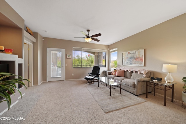 living area featuring carpet floors, baseboards, and a ceiling fan