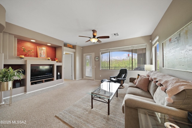 carpeted living room featuring baseboards, visible vents, and a ceiling fan