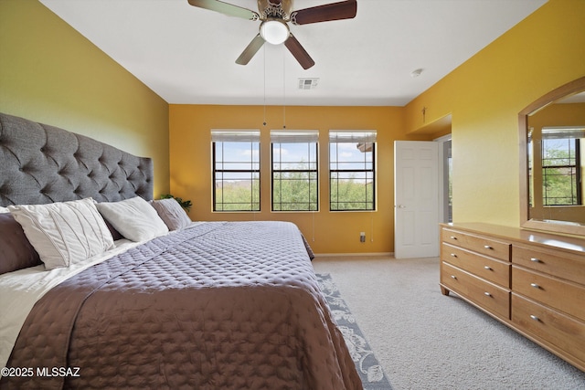 bedroom with baseboards, visible vents, a ceiling fan, and light colored carpet