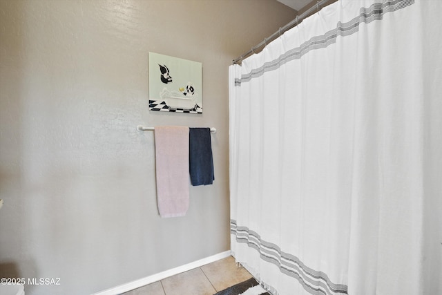 full bath featuring tile patterned flooring and baseboards