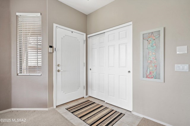 foyer featuring light tile patterned floors and baseboards