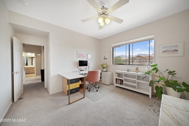 office area featuring light carpet, ceiling fan, and baseboards