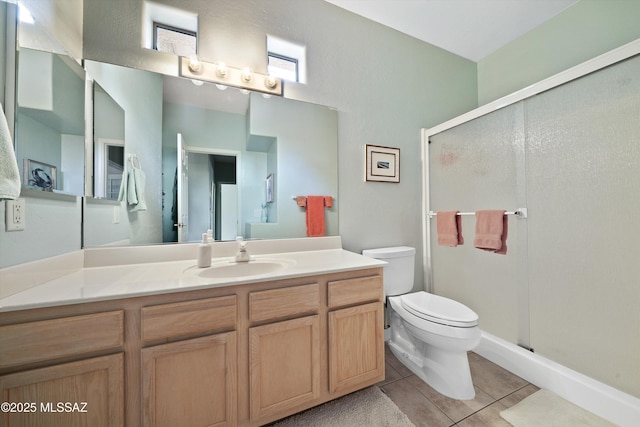 full bathroom with vanity, a shower stall, toilet, and tile patterned floors