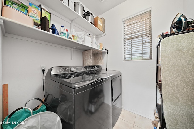 laundry area featuring laundry area, light tile patterned floors, and washer and clothes dryer