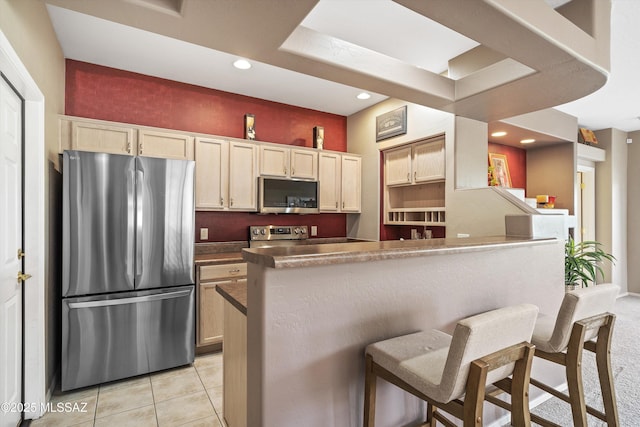 kitchen featuring a breakfast bar, light tile patterned floors, stainless steel appliances, recessed lighting, and a peninsula