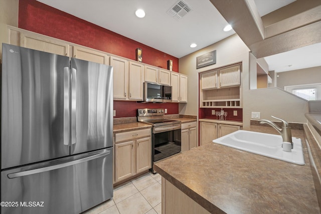 kitchen with visible vents, appliances with stainless steel finishes, light brown cabinets, a sink, and light tile patterned flooring