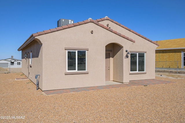 rear view of house featuring central air condition unit, a tile roof, fence, and stucco siding